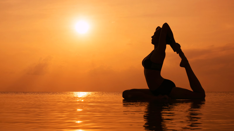 Woman Practicing Yoga at Sunrise